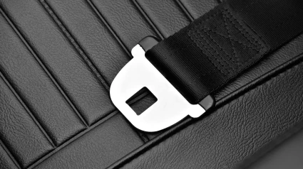 Cinturón de seguridad en un coche clásico sobre un asiento de cuero en una exposición de coches.