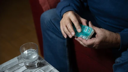 Imagen de recurso de las manos de un anciano tomando pastillas