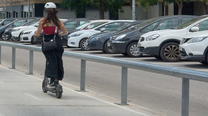 Una persona en patinete eléctrico circula por una acera de una calle de la ciudad de Viladecans