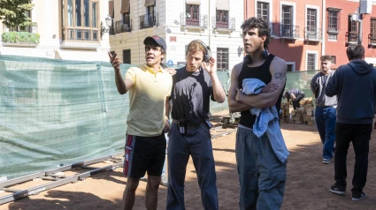 Los directores de cine Javier Ambrossi (i) y Javier Calvo (d), conocidos como Los Javis, dan explicaciones en la céntrica Plaza Nueva de Granada, junto al turístico Paseo de los Tristes, que se ha convertido este jueves en el set de rodaje de 'La bola negra', para el que han transformado y ambientado este espacio en la Segunda República con la participación de más de 200 figurantes