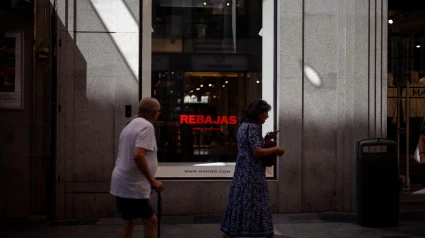 Los peatones pasan junto a un cartel de rebajas en una tienda del centro de Madrid.