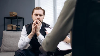 Paciente sentado en el diván durante la consulta del psicólogo.