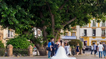 Una novia y un novio posando para fotografías de boda en el puente de Triana, Sevilla