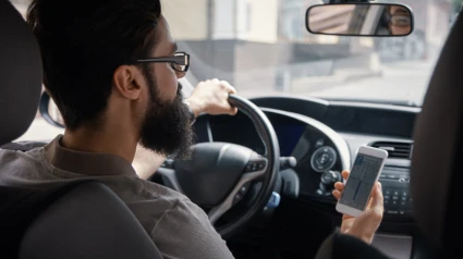 Hombre consulta móvil al volante