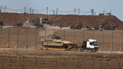 Un camión militar israelí que transporta vehículos blindados de transporte de personal sale de la Franja de Gaza tras el anuncio de Trump sobre el acuerdo entre Israel y Hamás.