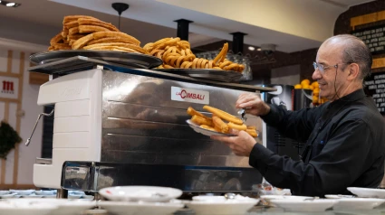 Un camarero sirve churros y porras tradicionales en Madrid