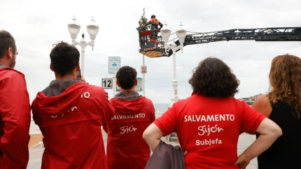 Personal de Salvamento colocan un ramo de laurel en la playa de San Lorenzo de Gijón