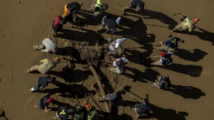 Voluntarios limpian una calle de Paiporta hace un año