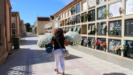 Una mujer lleva flores en uno de los cementerios de Lorca, esta semana