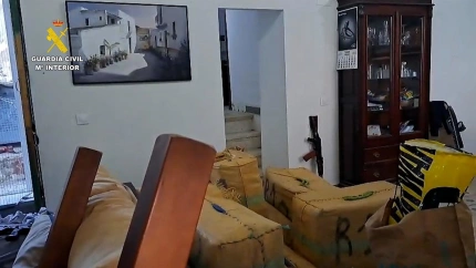 Fardos y armas incautadas en la casa