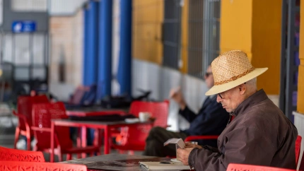 Un jubilado con sombrero de paja relajándose en una cafetería de Ronda