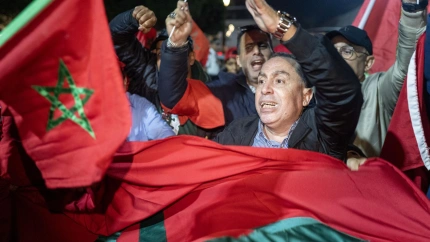 La gente ondea banderas y celebra en una calle de Rabat.