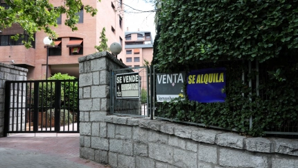 En la valla de una urbanización, se ven colgados dos carteles de 'Se vende piso' y uno de 'Se alquila'.