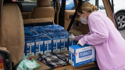 Una voluntaria trae leche al almacén de la Parroquia de San Juan de Dios, en la UVA de Vallecas