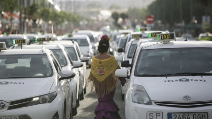 Archivo - Una flamenca circula entre taxis en la parada habilitada en la Feria de Abril, en foto de archivo.