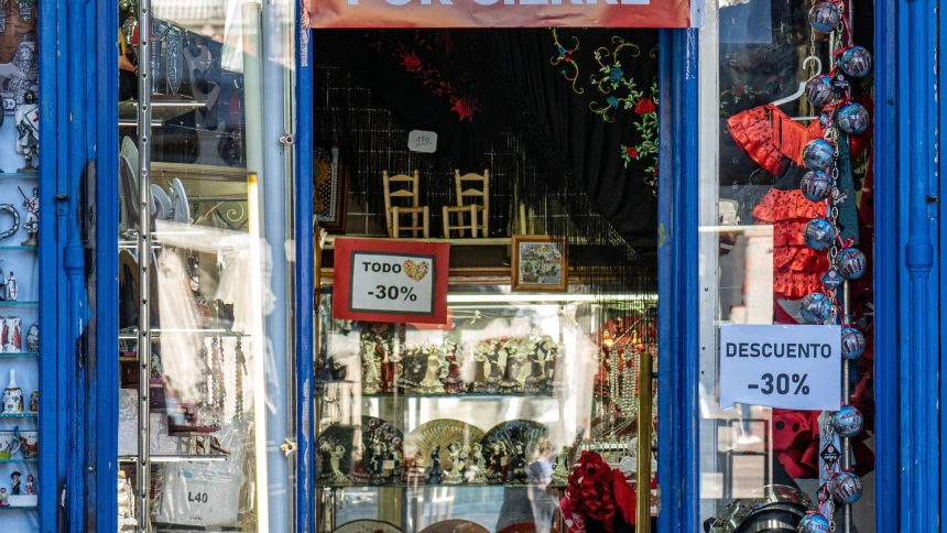 Bazar con cartel de liquidación por cierre, en uno de los soportales de la plaza principal de Madrid.