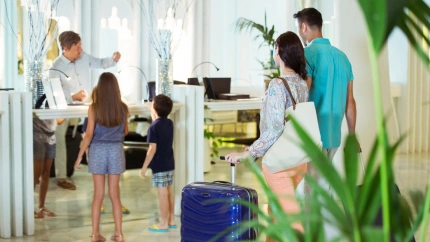 Familia con dos niños en la recepción del vestíbulo del hotel.