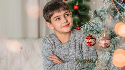 Un niño junto al árbol de Navidad