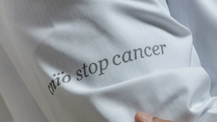Detalle de una de las batas donde se lee 'cnio stop cancer' del Centro Nacional de Investigaciones Oncológicas (CNIO)