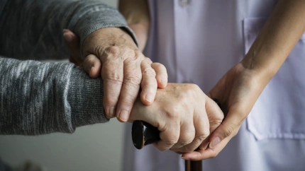 Un asistente de ayuda social atiende a un anciano en una imagen de archivo