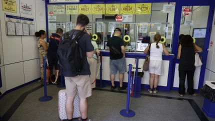 Varias personas hacen cola en una administración de Lotería en Madrid