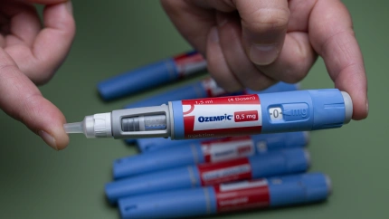 Una mano que sostiene una jeringuilla de inyección de Ozempic (0,5 mg), con otras jeringuilla en el fondo, simboliza el control de la diabetes