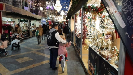 Un padre y su hija pasean por el mercado de Navidad de Lorca el día de su apertura