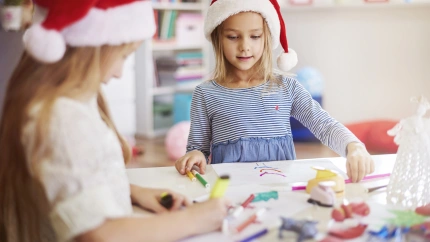 Dos niñas hacen manualidades en un taller de actividades navideñas