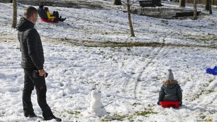 Niños junto a sus padres disfrutan con un trineo de la nieve en el alto de Urkiola, en Bizkaia