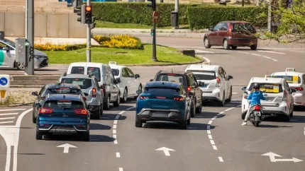 Tráfico tranquilo en el Paseo de la Castellana el domingo por la mañana, con coches circulando libremente bajo la luz dorada del amanecer.