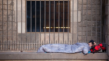 Hombre sin hogar durmiendo en la Plaza Medieval del siglo XIV, Plaça del Rei, Barcelona