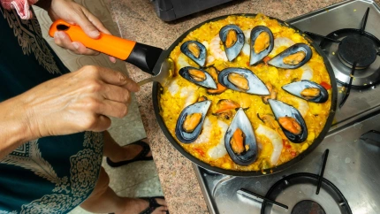 Mujer cocinando un arroz con mejilones