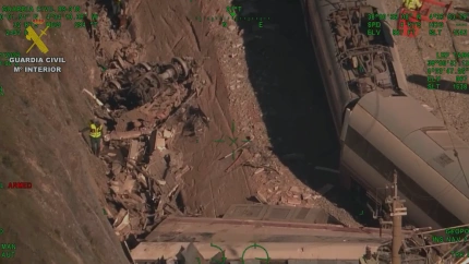 Agentes caninos de la Guardia Civil buscan entre el amasijo de hierros