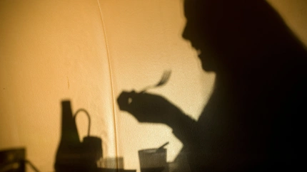 sombra de una mujer comiendo sola