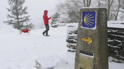 Una persona pasea a su perreo en O Cebreiro (Lugo), cubierto este viernes por un manto de nieve