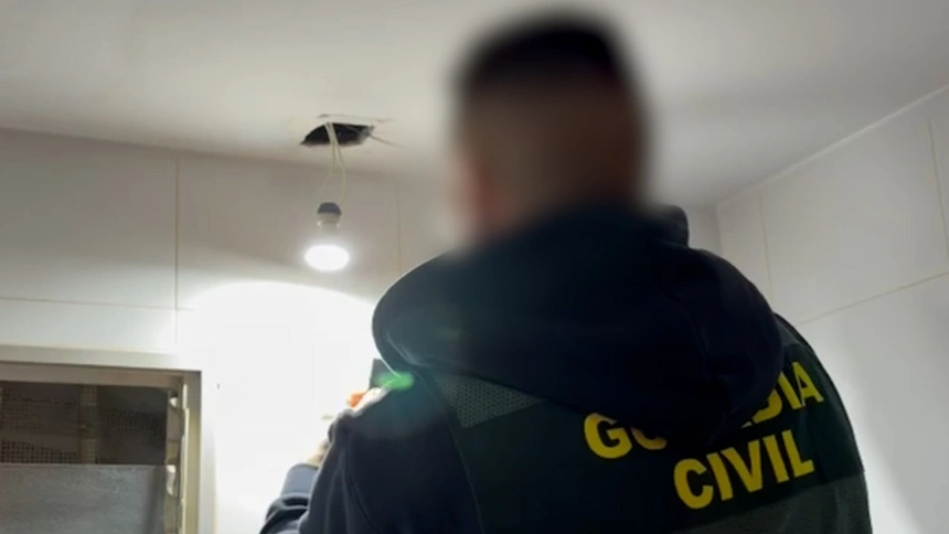 Agente desmontando la cámara espía