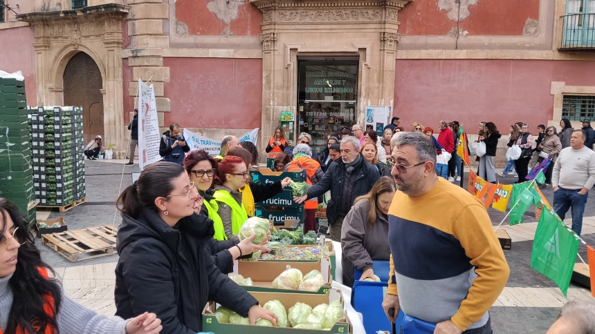 Agricultores repartiendo frutas y hortalizas en la plaza de Belluga