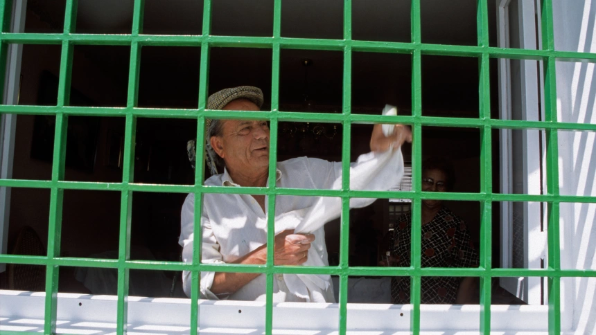 Un jubilado limpiando una ventana en Frigiliana