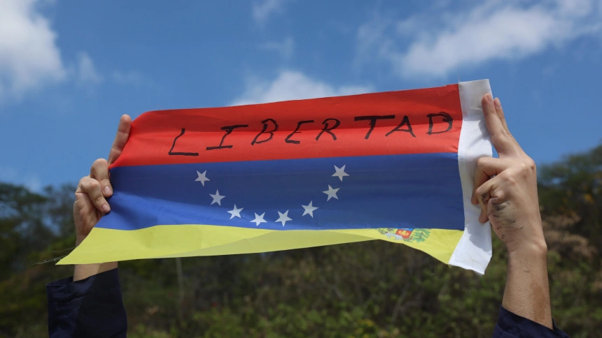 Una persona sostiene una bandera de Venezuela durante una manifestación