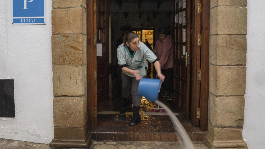 Vecinos de Grazalema intentan achicar agua de sus casa y locales debido a las intensas lluvias