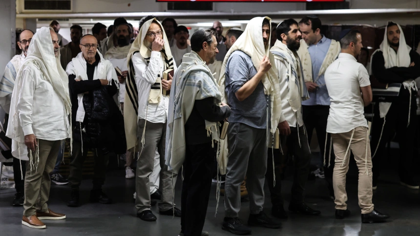 La gente reza mientras se refugia en un estacionamiento subterráneo luego de las alarmas por misiles provenientes de Irán.