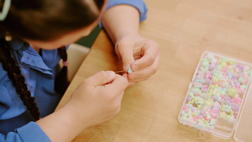 Una niña con síndrome de Down haciendo una pulsera