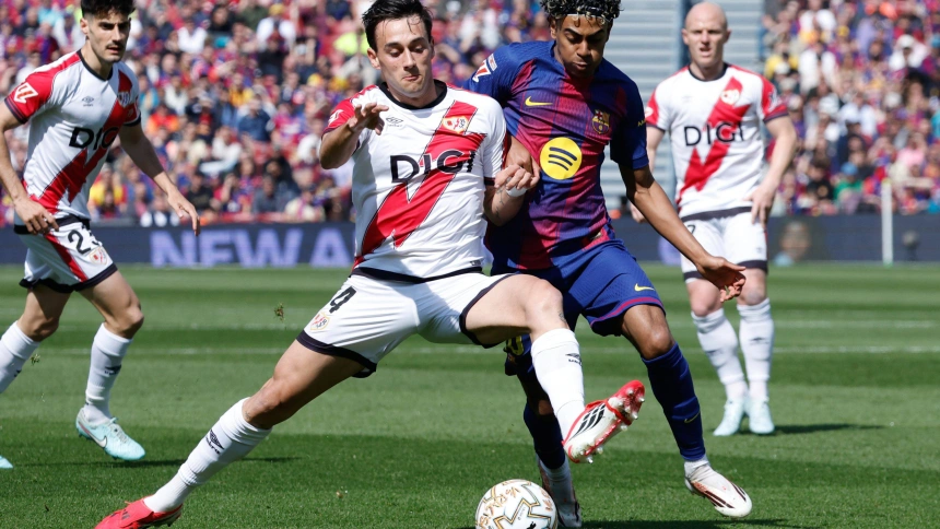 Pedro Díaz y Lamine Yamal pelean por un balón durante el Barça-Rayo