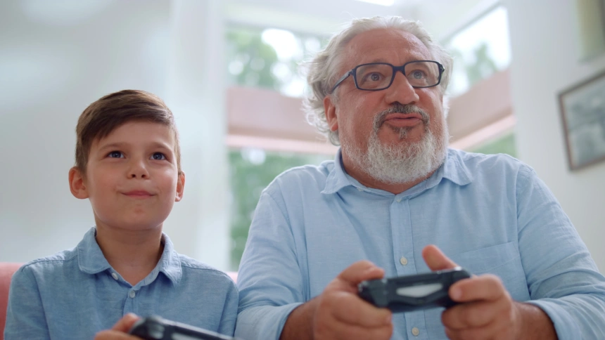 Abuelo y nieto juegan juntos a los videojuegos.