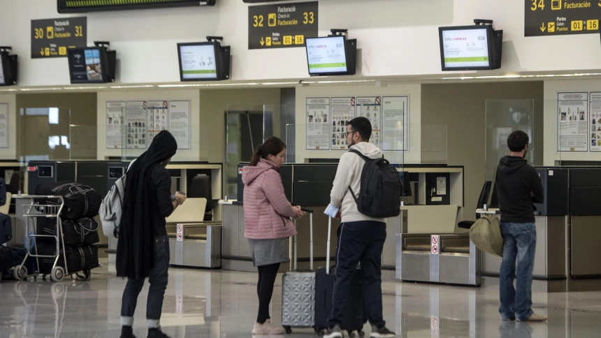 Pasajeros que viajan desde Menorca dirección a Barcelona esperan en uno de los mostradores del Aeropuerto de Menorca