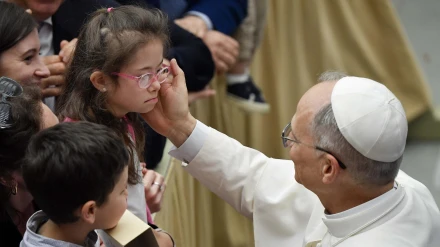 El papa León XIV saluda a una niña mientras preside una audiencia con la Curia romana y los empleados del Estado de la Ciudad del Vaticano este sábado