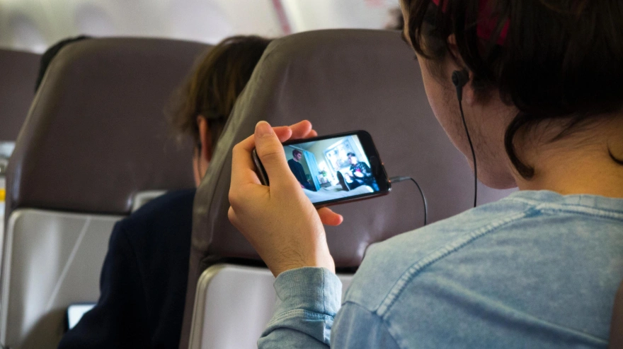 Un joven utiliza su teléfono móvil en pleno vuelo