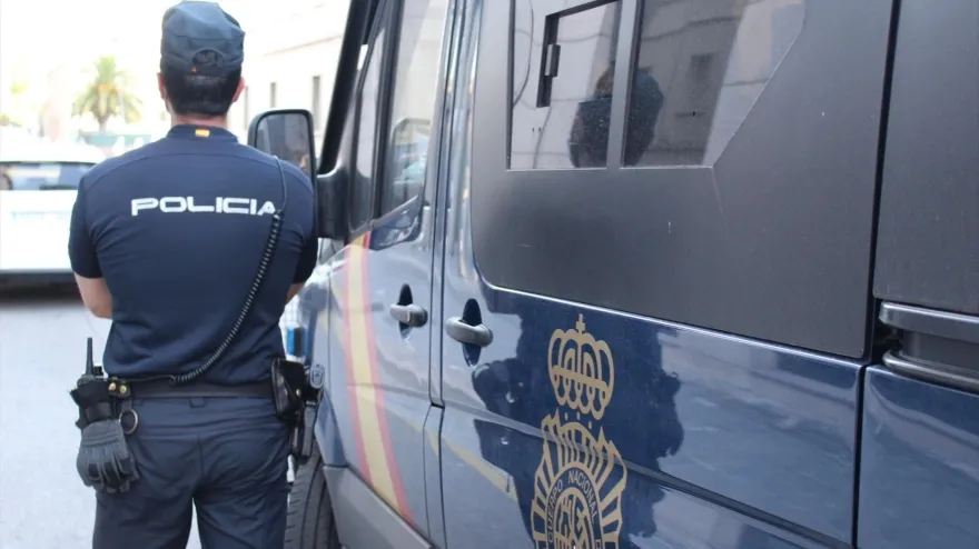 Agente de Policía Nacional junto a un furgón
