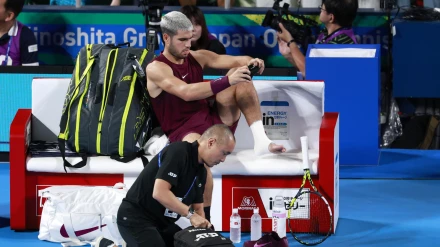 Alcaraz se coloca el calcetín izquierdo tras serle vendado el tobillo en el que se hizo daño.