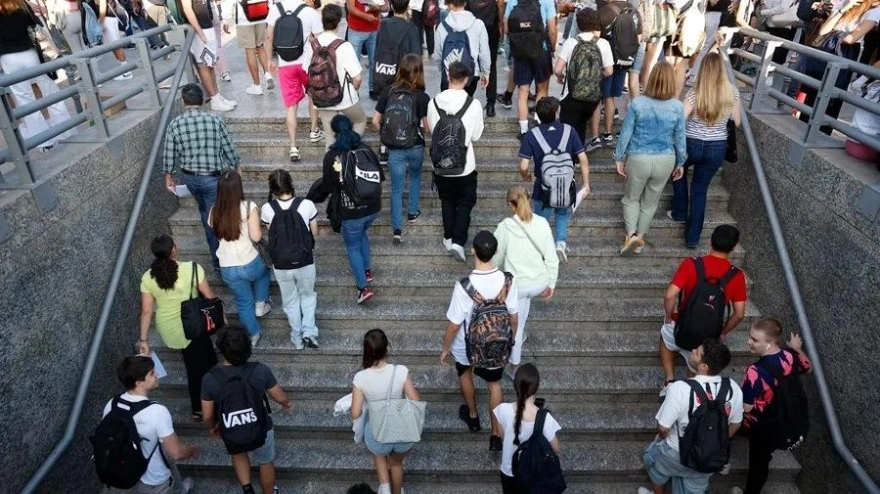 Grupos de jóvenes estudiantes ascendiendo una escalera